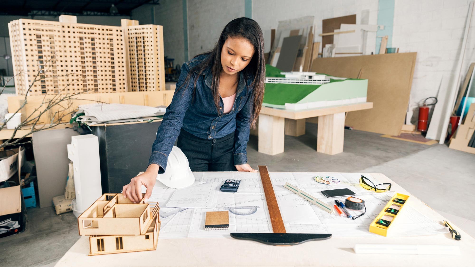 african-american-woman-with-model-house-table-near-safety-helmet-equipments